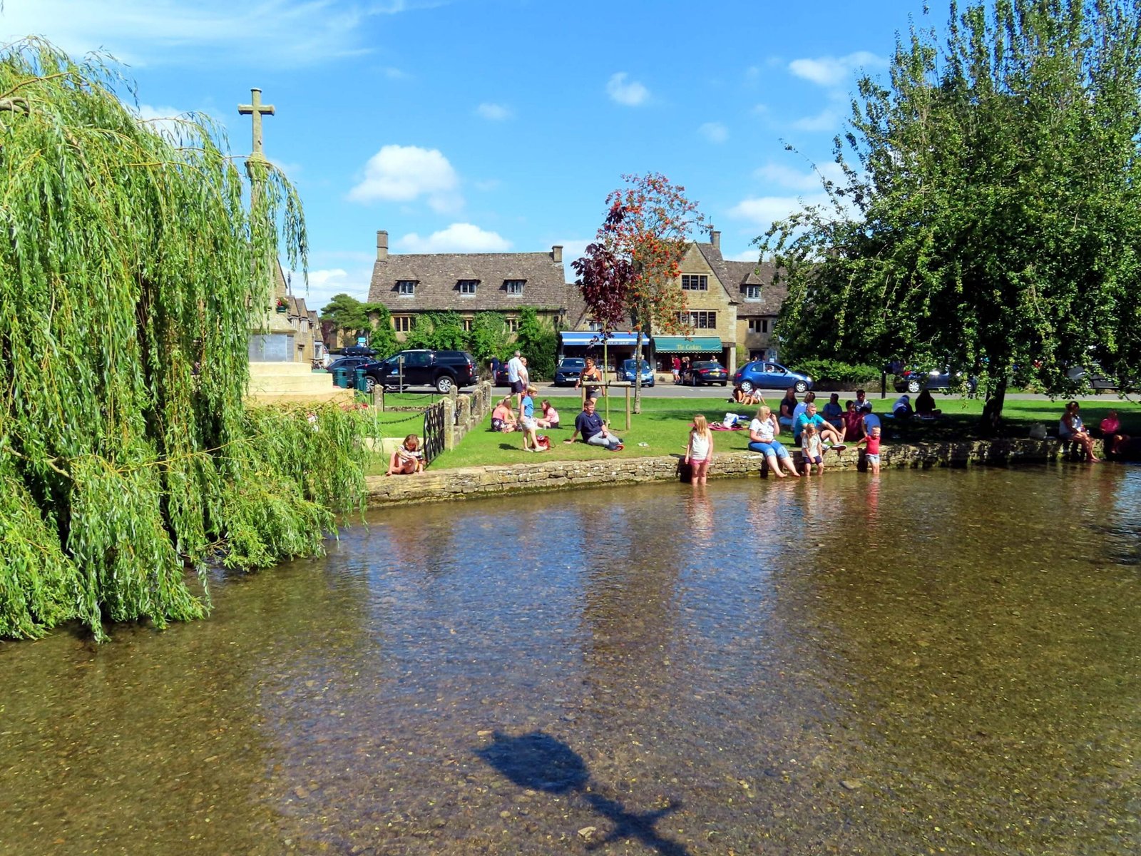 Children paddling river willow trees riverside