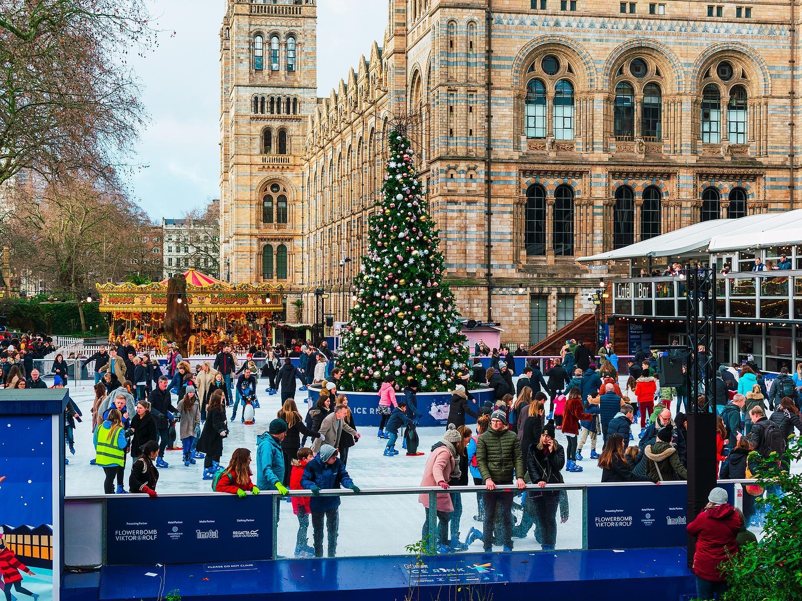 A festive outdoor seasonal ice rink lit up at night in a UK city centre