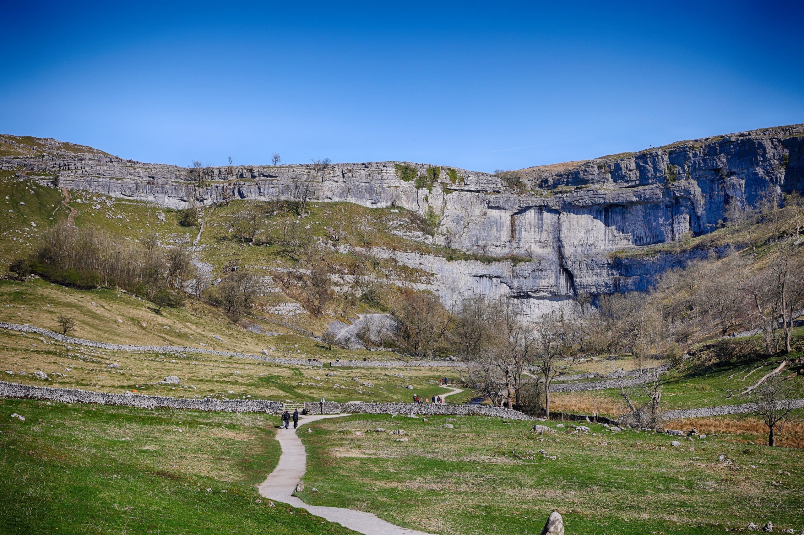The vast curved limestone cliff of Malham Cove in the Yorkshire Dales