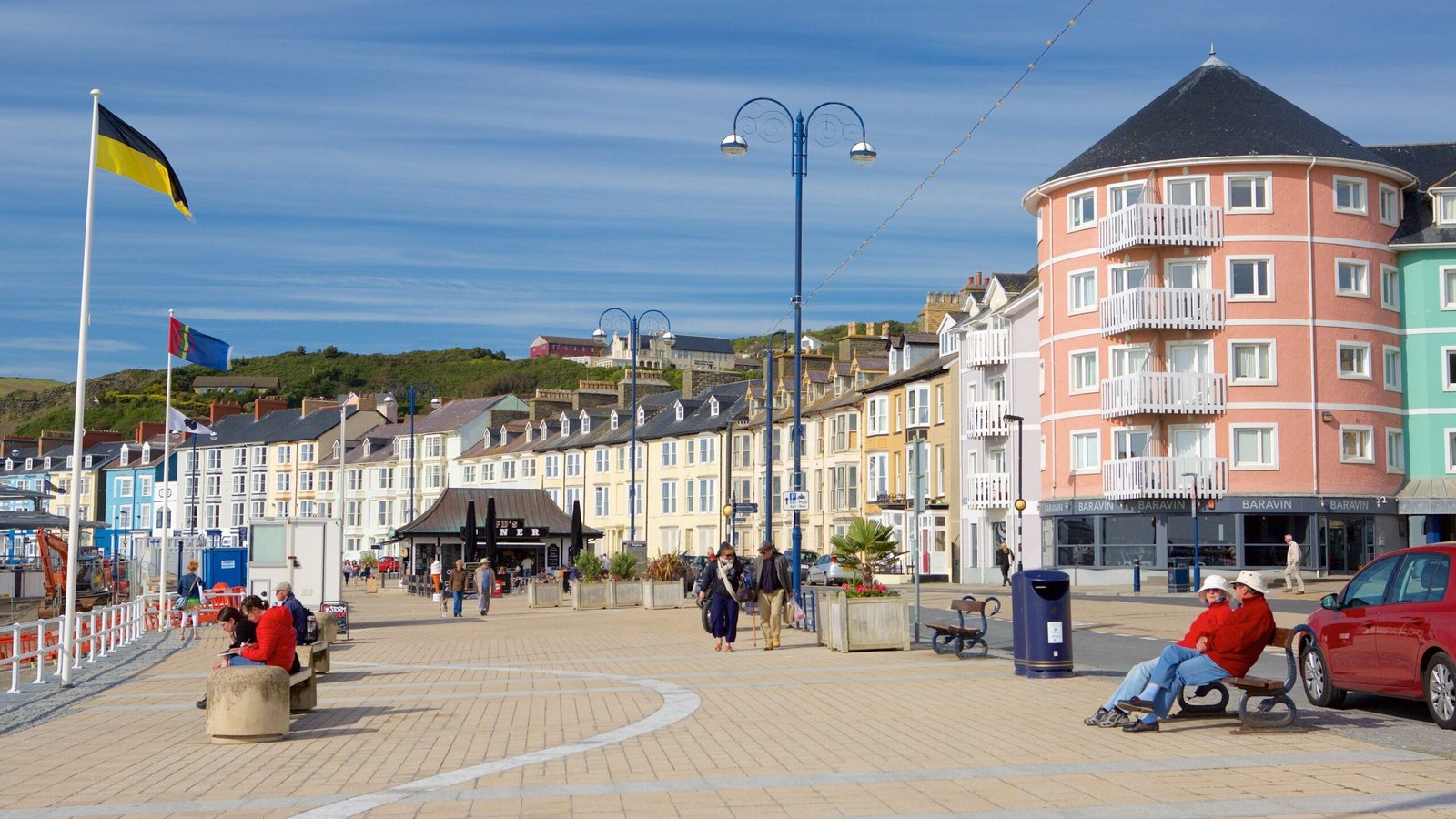 Visitors walking along Aberystwyth promenade beside Cardigan Bay