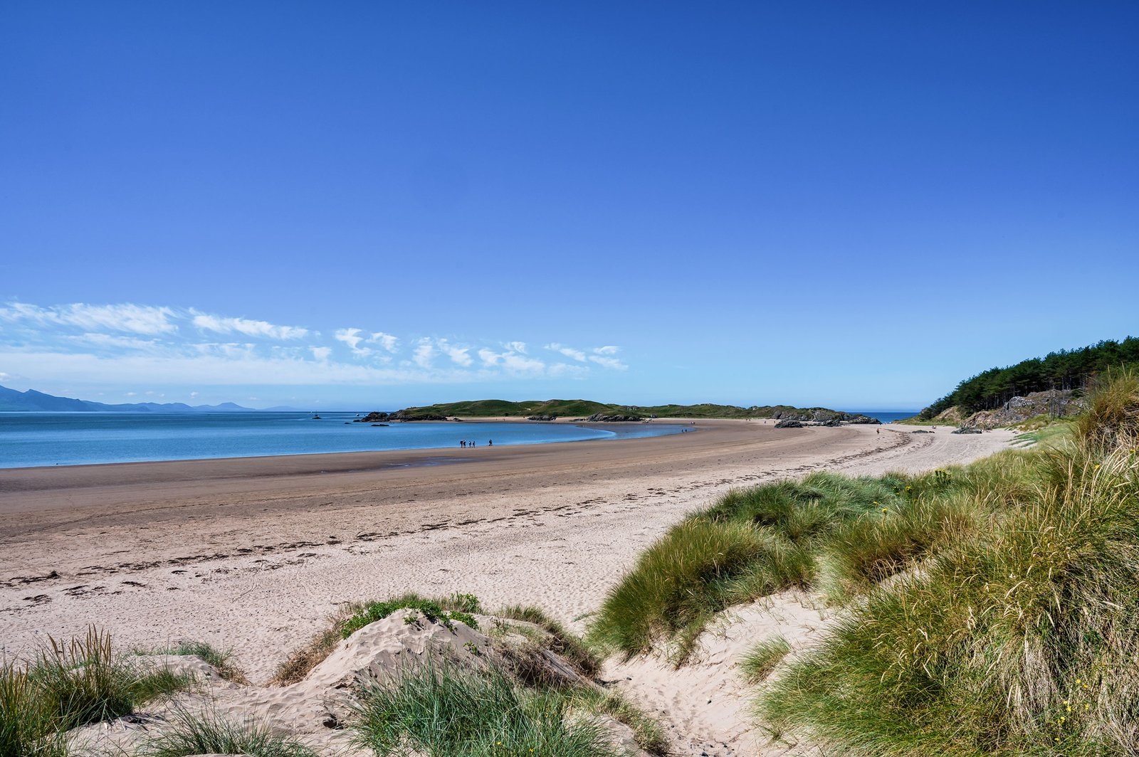 Visitors exploring the lighthouse towers and coast of Ynys Llanddwyn